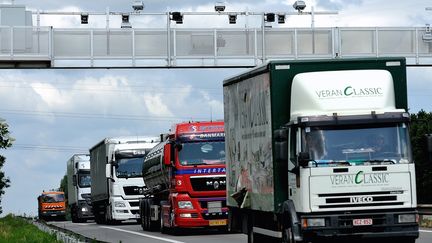 Des poids-lourds passent sous un portique qui leur permet de "pointer" pour l'&eacute;cotaxe, le 27 juin 2013 &agrave; Armenti&egrave;res (Nord). (PHILIPPE HUGUEN / AFP)