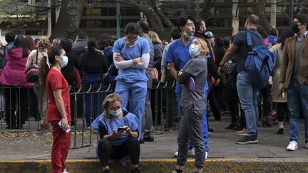 Des personnes attendent dans la rue à Mexico (Mexique), après un séisme de magnitude 5,8, le 7 décembre 2023. (RODRIGO ARANGUA / AFP)