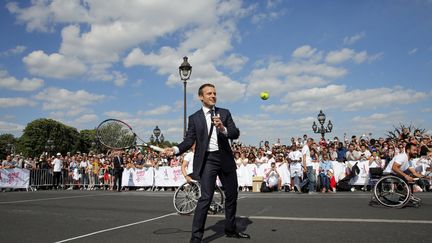 Emmanuel Macron joue au tennis sur le pont Alexandre III à Paris, le 24 juin 2017, pour soutenir la candidature de la capitale comme ville organisatrice des Jeux olympiques et paralympiques 2024. (JEAN-PAUL PELISSIER / POOL / REUTERS POOL)