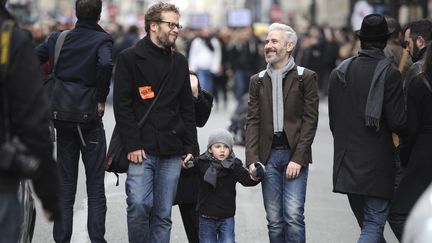 Un couple d'hommes et un enfant participent &agrave; la manifestation en faveur du projet de loi sur le "mariage pour tous", le 16 d&eacute;cembre 2012, &agrave; Paris. (FRED DUFOUR / AFP)