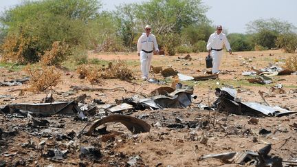 Des enqu&ecirc;teurs sur le site du crash du vol d'Air Alg&eacute;rie, au Mali, le 29 juillet 2014. (SIA KAMBOU / AFP)