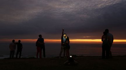 Un couple se prend en photo devant un coucher de soleil pr&egrave;s de Lima (P&eacute;rou), le 9 f&eacute;vrier 2015. (MARIANA BAZO / REUTERS)