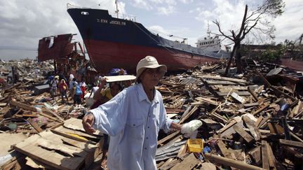 Des survivants errent &agrave; travers les d&eacute;bris dans la ville d&eacute;truite de Tacloban (Philippines), le 10 novembre 2013 (AARON FAVILA / AP / SIPA)