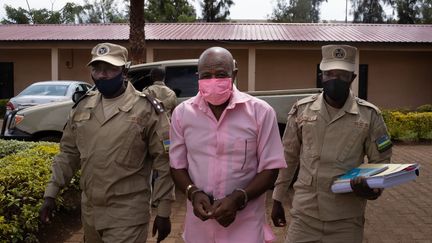 Paul Rusesabagina encadré par deux policiers arrive au tribunal de Kigali, le 2 octobre 2020. Sa demande de libération pour raison de santé a été une nouvelle fois rejetée. (SIMON WOHLFAHRT / AFP)