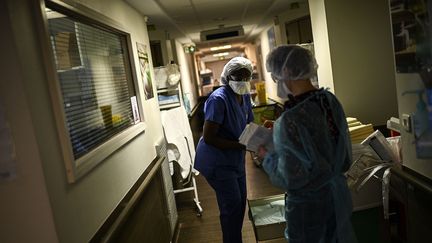 Des membres du personnel médical de l'hôpital Cochin, à Paris, travaillent dans l'unité de Covid-19, le 18 mars 2021. (CHRISTOPHE ARCHAMBAULT / AFP)