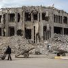 Un Irakien pousse une charrette devant les décombres d'un bâtiment à Mossoul, le 13 janvier 2019. (ZAID AL-OBEIDI / AFP)