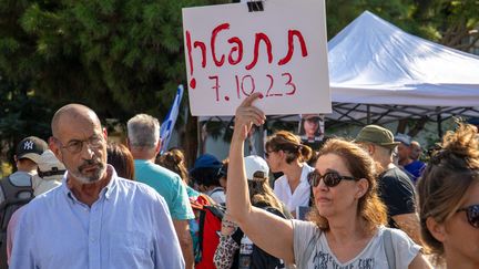 Une femme brandit une pancarte sur laquelle est écrit : "Démissionnez ! 7 octobre 2023", en référence à Benyamin Nétanyahou et à l'assaut du Hamas en Israël, lors d'une manifestation à Tel-Aviv (Israël), le 14 octobre 2023. (YAHEL GAZIT / MIDDLE EAST IMAGES / AFP)