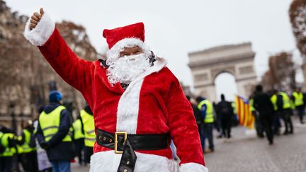 Un homme déguisé en père noël lors de la manifestation sur les Champs-Elysées à Paris, le 15 décembre 2018. (CHRISTOPH HARDT / GEISLER-FOTOPRES / AFP)