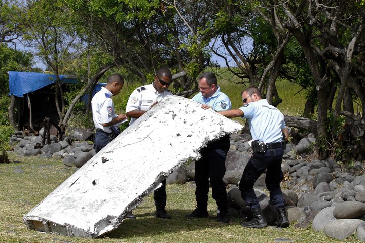 Des gendarmes manipulent un d&eacute;bris d'avion,&nbsp;sur le littoral de Saint-Andr&eacute; de La R&eacute;union.&nbsp; (MAXPPP)