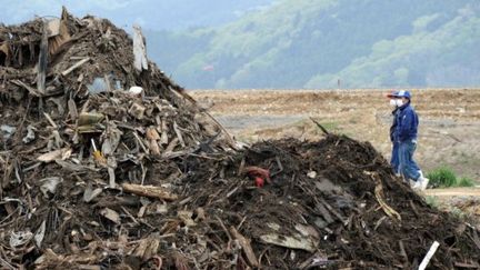 Villageois près d'une école détruite par le tsunami à Ishinomaki (est du Japon) (AFP)