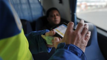 Un gendarme contrôle une carte d'identité à Thun L'évêque (Nord), le 26 janvier 2016. (FRANCOIS LO PRESTI / AFP)