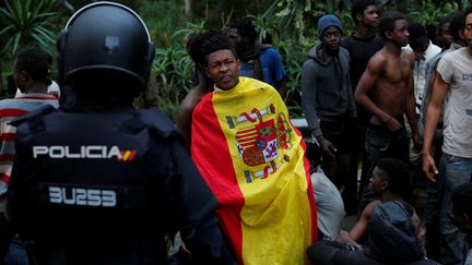 Un migrant&nbsp;revêt le drapeau espagnol après avoir franchi la clôture entre le Maroc et l'enclave espagnole de Ceuta, le 17 février 2017. (REUTERS)