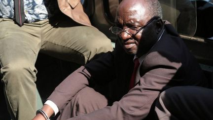 Douglas Mahiya, le porte-parole de l'Association des vétérans de la guerre de libération du Zimbabwe (ZNLWVA), arrive menotté le 29 juillet 2016 au tribunal d'Harare, la capitale du Zimbabwe. Il est accusé d'avoir «sapé» l'autorité du président Robert Mugabe.  (WILFRED KAJESE / AFP)