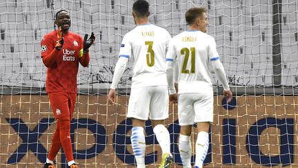 Steve Mandanda motive ses coéquipiers lors du match de l'OM face à l'Olympiakos, le 1er décembre 2020 (NICOLAS TUCAT / AFP)