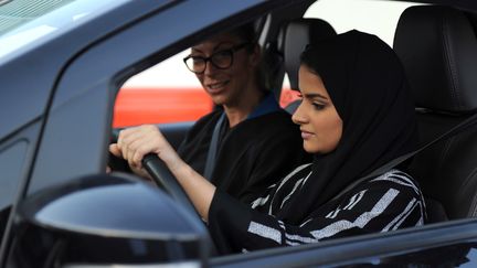 Une femme saoudienne apprend à conduire avec une formatrice italienne, le 7 mars 2018, à Jeddah (Arabie saoudite). (AMER HILABI / AFP)