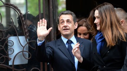 Nicolas Sarkozy et son &eacute;pouse, Carla Bruni-Sarkozy, sortant d'un bureau de vote, le 22 avril 2012, jour du premier tour de l'&eacute;lection pr&eacute;sidentielle, &agrave; Paris. (ERIC FEFERBERG / POOL)