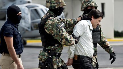 Le baron de la drogue&nbsp;Joaquin Guzman, dit "el Chapo", escort&eacute; par des militaires apr&egrave;s son arrestation, le 22 f&eacute;vreir 2014 &agrave; Mexico. (RONALDO SCHEMIDT / AFP)