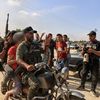 Des combattants palestiniens emmènent une Israélienne faite prisonnière sur une moto le 7 octobre 2023, à Khan Younès, dans le sud de la bande de Gaza. (AFP)