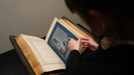 Un livre contenant des illustrations des Fables de La Fontaine réalisées par le peintre français Jean-Baptiste Oudry, présenté chez Christie's, à New York, le 24 janvier 2023. (CECILIA SANCHEZ / AFP)