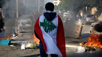 Un manifestant anti-gouvernemental libanais, enveloppé dans un drapeau national à Beyrouth,&nbsp;le 14 janvier 2020 (photo d'illustration). (PATRICK BAZ / AFP)