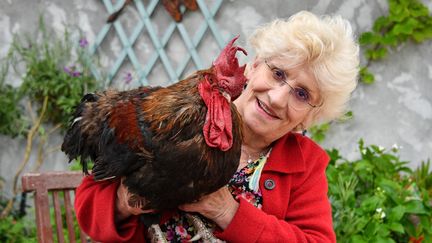 Corinne Fesseau avec son coq "Maurice", à Saint-Pierre-d'Oléron à La Rochelle, dans l'ouest de la France,&nbsp;le 5 juin 2019. (XAVIER LEOTY / AFP)