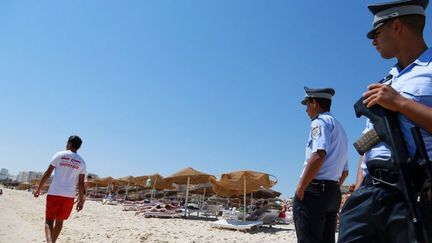 Policiers tunisiens patrouillant sur une plage de Sousse, le 2 juillet 2015, une semaine après l'attaque terroriste qui a tué 38 personnes (et en a blessées 36 autres). (AFP - MED AMINE BEN AZIZA - ANADOLU AGENCY)