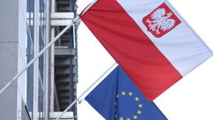 Un drapeau polonais et un drapeau européen à Bruxelles, le 8 octobre 2021. (KENZO TRIBOUILLARD / AFP)