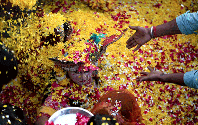 &nbsp; (A Vridavan, des prêtres font disparaître sous les pétales un couple symbolisant Krishna et Radha. © Géo Philippe Bourseiller.)