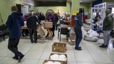 Des Ukrainiens reçoivent des colis alimentaires dans la région de Donetsk, le 17 février 2024. (JOSE COLON / ANADOLU / AFP)