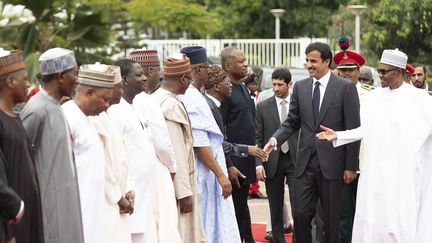 En tournée africaine, l'émir du Qatar Cheikh Tamim Ben Hamad Al Thani (C) en provenance de Kigali, accueilli à Abuja au Nigeria par le président Muhammadu Buhari (D), le 23 avril 2019. (QATAR EMIRATE COUNCIL / HANDOUT / ANADOLU AGENCY)