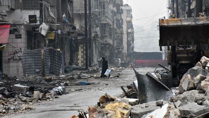 Une femme quitte un quartier d'Alep après l'arrivée des forces gouvernementales, le 13 décembre 2016. (GEORGE OURFALIAN / AFP)