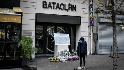 Une femme se tient devant une plaque commémorative posée à l'extérieur de la salle de concert du Bataclan où a eu lieu en novembre 2015&nbsp;une attaque&nbsp;terroriste, le 13 novembre 2019 à Paris. (STEPHANE DE SAKUTIN / AFP)