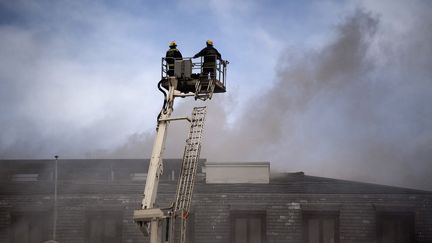 Des pompiers luttent contre l'incendie du Parlement, le 2 janvier 2022 au Cap (Afrique du Sud). (RODGER BOSCH / AFP)