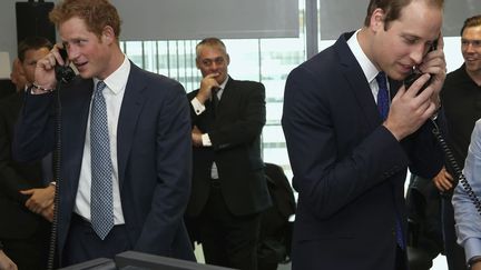 Les princes Harry (G) et William (D) tentent de r&eacute;colter des dons lors d'un &eacute;v&eacute;nement caritatif organis&eacute; &agrave; la City &agrave; Londres (Royaume-Uni), le 11 septembre 2013. (REUTERS)