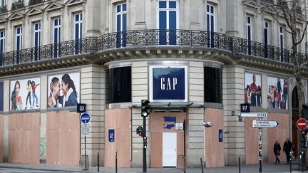 En prévisions des manifestations, plusieurs magasins dont GAP ont recouvert leur devanture de panneaux en bois, le 8 décembre 2018.&nbsp; (STEPHANE MAHE / REUTERS)