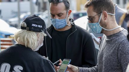 Des clients montrent leur "passeport vert" à l'entrée d'un stade à Tel Aviv (Israël), le 5 mars 2021. (JACK GUEZ / AFP)