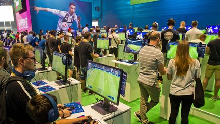 Des visiteurs s'entrainent sur le jeu Fifa 2019 au salon Gamescom de Cologne (Allemagne). (MICHAEL GOTTSCHALK / GETTY IMAGES EUROPE)