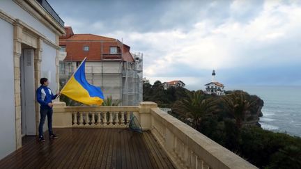 Un militant brandit un drapeau ukrainien sur le balcon de la résidence. (CAPTURE D'ECRAN YOUTUBE)