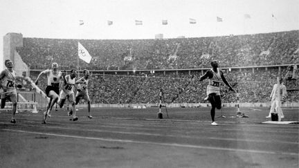 Jesse Owens remporte la médaille d'or du 100 mètres au stade olympique de Berlin le 3 août 1936. L'américain de 22 ans reviendra en héros dans son pays, avec 4 médailles d'or, le 100 et le 200 mètres, le relais 4 x 100 mètres et celle de la finale du saut en longueur. (KEYSTONE / HULTON ARCHIVE / GETTY IMAGES)