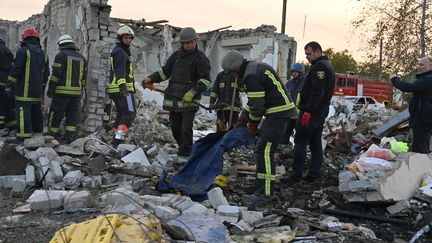 Les secours ukrainiens interviennent après la frappe mortelle qui a touché, le 5 octobre 2023, le village de Groza, dans l'est du pays. (SERGEY BOBOK / AFP)