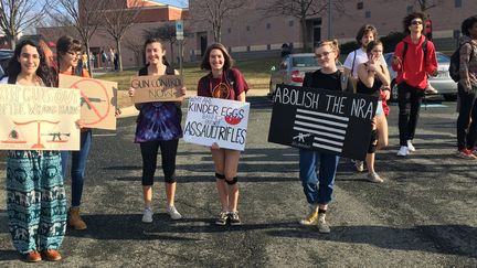 Contre la violence provoquée par la libre circulation des armes aux États-Unis, et contre le puissant lobby NRA (National Rifle Association), des étudiantes du Maryland brandissent des panneaux à Silver Springs, lors d'une marche de protestation (21 février 2018)
 (Ronald Edwards / CrowdSpark / AFP)