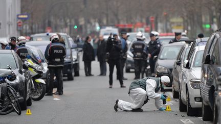 Des policiers enqu&ecirc;tent dans le 11e arrondissement de Paris apr&egrave;s l'attaque du si&egrave;ge de "Charlie Hebdo", le 7 janvier 2015. (DURSUN AYDEMIR / ANADOLU AGENCY / AFP)