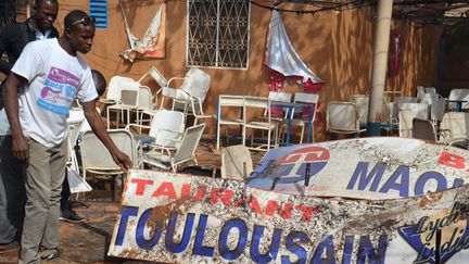 Un Nig&eacute;rien se tient dans les d&eacute;combres d'un restaurant fran&ccedil;ais de Niamey (Niger), samedi 17 janvier 2015, apr&egrave;s de violentes manifestations contre "Charlie Hebdo". (BOUREIMA HAMA / AFP)