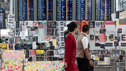 Des passants à l'aéroport de Hong Kong, le 13 août 2019.&nbsp; (PHILIP FONG / AFP)