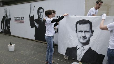 Des activistes de Reporters sans frontières placardent des affiches de campagne pour défendre la liberté de la presse, à Paris, le 3 mai 2013. (KENZO TRIBOUILLARD / AFP)