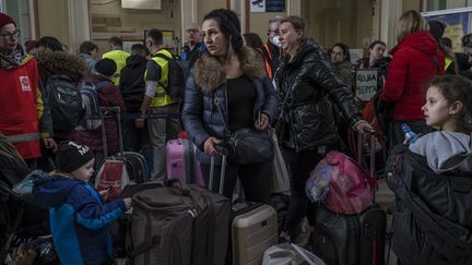 Des réfugiés ukrainiens patientent dans le hall de la gare de&nbsp;Przemysl, dans le sud de la Pologne, le 26 mars 2022. (ANGELOS TZORTZINIS / AFP)