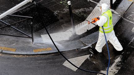 Un employé municipal désinfecte la rue, le 14 avril 2020 à Cannes (Alpes-Maritimes). (EMMANUEL FRADIN / HANS LUCAS / AFP)