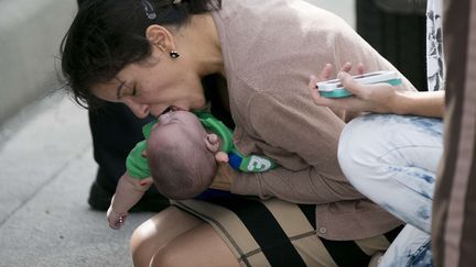 Une femme tente de r&eacute;animer son neveu &acirc;g&eacute; de cing mois victime d'un accident de voiture en Floride (Etats-Unis), le 20 f&eacute;vrier 2014. (AL DIAZ / AP / SIPA)