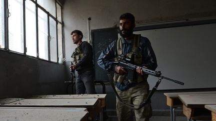 Des rebelles ont pris position dans une &eacute;cole d&eacute;sert&eacute;e dans le district d'Alep, le 26 octobre 2012. (PHILIPPE DESMAZES / AFP)