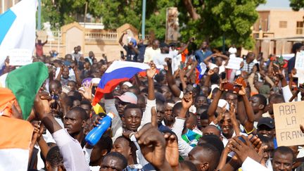 Des manifestants rassemblés en soutien aux militaires putschistes, brandissent des drapeaux russes, à Niamey, le 30 juillet 2023. (BALIMA BOUREIMA / ANADOLU AGENCY / AFP)